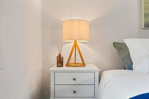a lamp on a night stand next to a bed at Private Modern Bungalow - Separate Entry in Brisbane