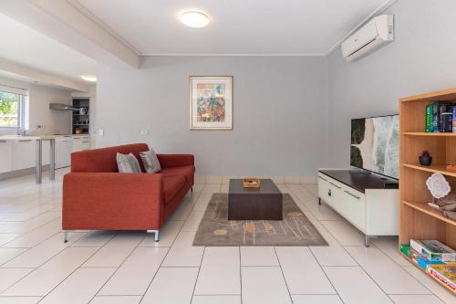 a living room with a red couch and a coffee table at Beachside 7 in Diamond Beach