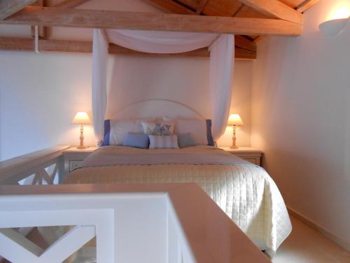 a bedroom with a bed with two tables and two lamps at HydraVista (Pearl) in Hydra