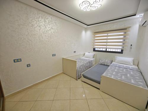 a bedroom with two beds and a window at Ryad el houda in Agadir
