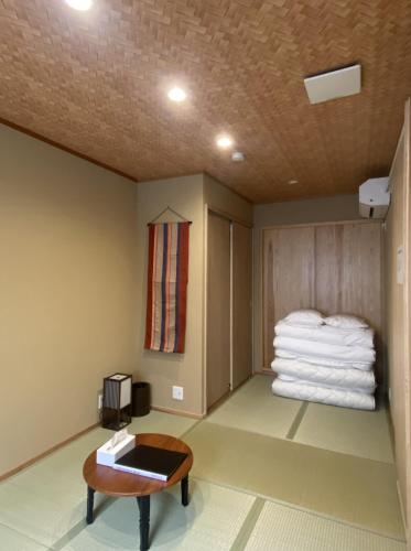 a room with a pile of towels and a table at 姫路城下町 巡 in Himeji