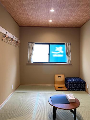 a room with a table and a couch and a window at 姫路城下町 巡 in Himeji