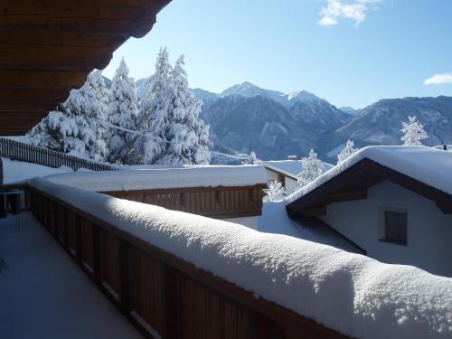 a snow covered roof of a house with mountains in the background at Haus Anemone in Serfaus