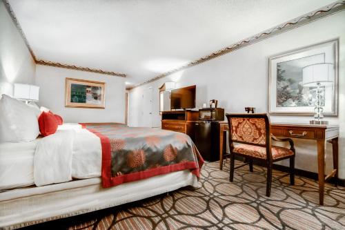 アトランタにあるラマダ プラザ ホテル アトランタ エアポートのベッドとデスクが備わるホテルルームです。