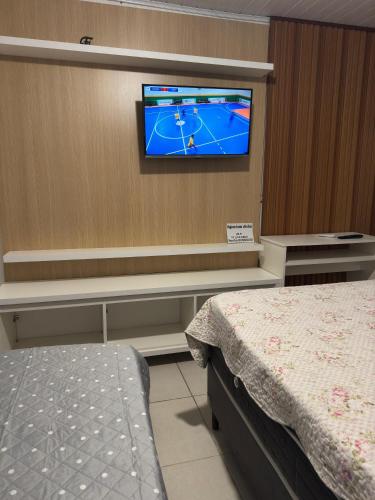 a hospital room with a tv on a wall at Casa Completa in Curitiba