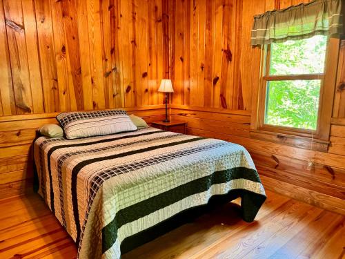 a bedroom with a bed in a wooden cabin at E-HOT SPRINGS MYSTIQUE - Historic Five Points Lake Hamilton in Hot Springs