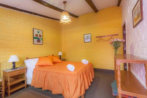 a bedroom with a bed and a yellow wall at Alojamiento Soledad in Huaraz