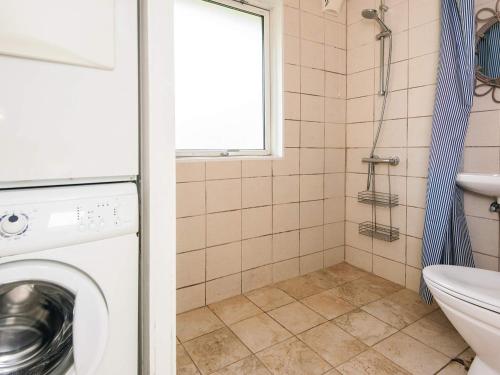 a washing machine in a bathroom with a window at 4 star holiday home in Ørsted-By Traum in Ørsted