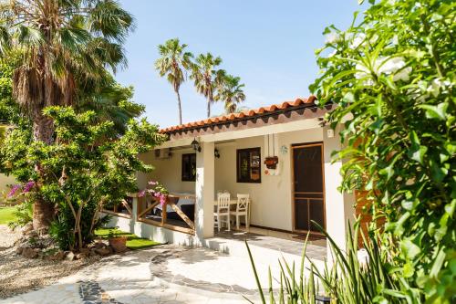 a rental house with a patio and palm trees at Casalina Garden 2 blocks to Palm Beach & Kitesurfing school in Palm-Eagle Beach