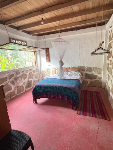 a bedroom with a bed with a lamp on it at Intimunay Shala Yoga Center in Las Núñez
