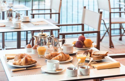 a breakfast table with eggs and croissants and coffee at Il Porticciolo in Laveno-Mombello