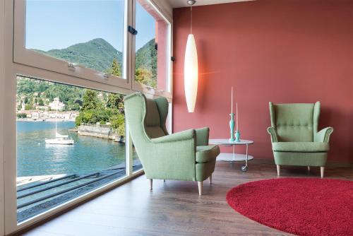 a living room with two chairs and a large window at Il Porticciolo in Laveno-Mombello