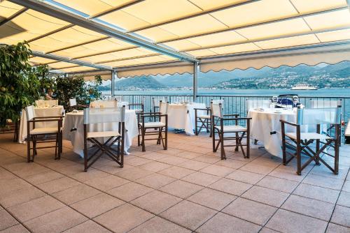 a restaurant with tables and chairs and a view of the water at Il Porticciolo in Laveno-Mombello