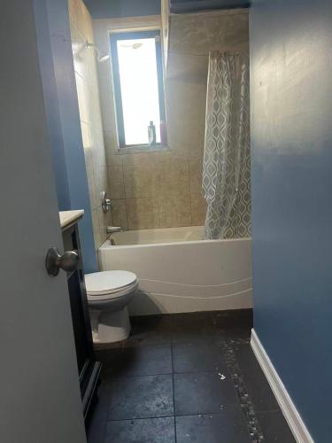 a bathroom with a tub and a toilet and a window at six bedroom house in Victoria