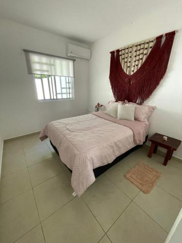 a bedroom with a large bed and a window at Casa del Conejo in Puerto Morelos