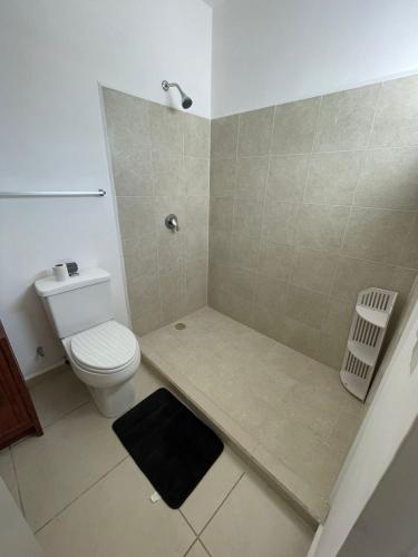 a small bathroom with a toilet and a shower at Casa del Conejo in Puerto Morelos