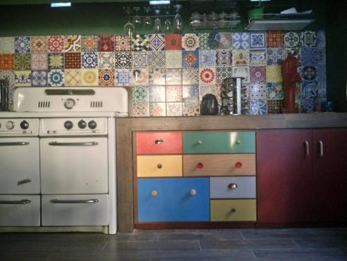 a kitchen with colorful cabinets and a tile wall at Casa de campo Miramar Norte in Miramar