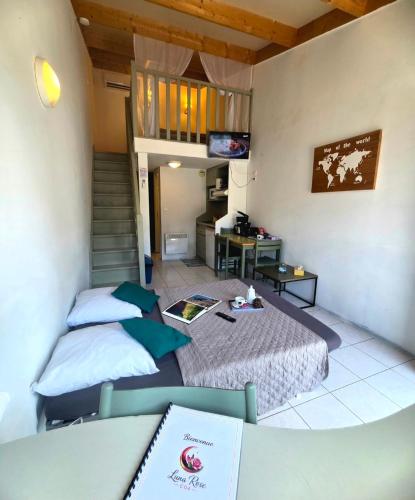 a small room with two beds and a desk at Studio Luna Rose in Merville