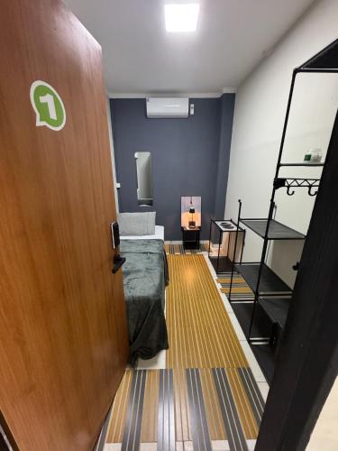 a room with a door and a bed in it at Maia Hostel in Várzea Grande