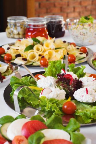 a table with several plates of food on it at Hotelik B&B Pod Dębami in Radwanice