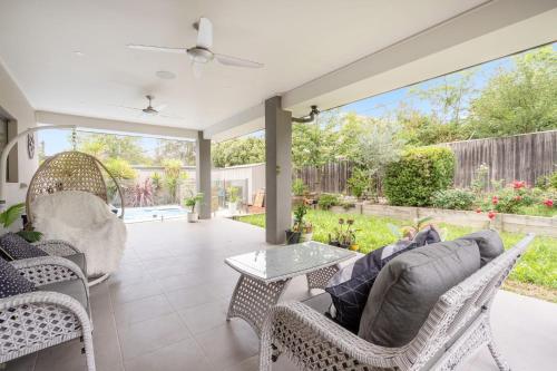 a patio with wicker chairs and a couch and a table at Charming 3-Bed Getaway with Pool & Garden Oasis in Lyons