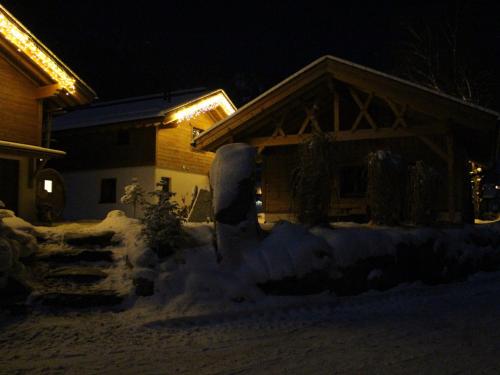 a house is covered in snow at night at Feriendorf X-Alp Lodges Ötztal in Sautens