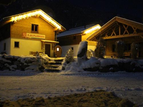 a building with snow in front of it at night at Feriendorf X-Alp Lodges Ötztal in Sautens
