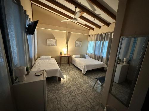 a hotel room with two beds and a mirror at Cabinas del Río in Upala