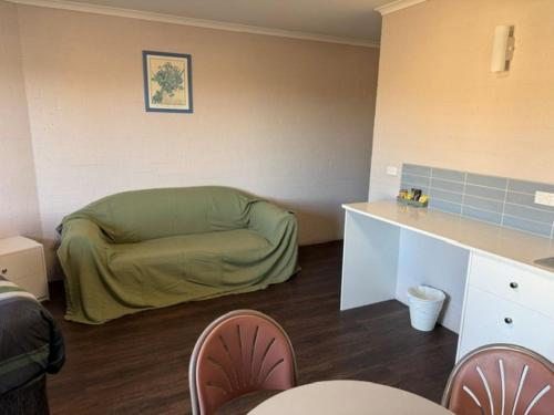 a living room with a green couch in a room at Ulladulla Harbour Motel in Ulladulla