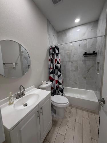 a bathroom with a sink and a toilet and a mirror at Room in Downtown Orlando! Close to everything! in Orlando