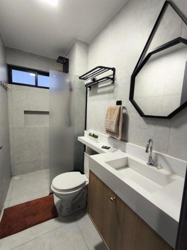 a bathroom with a toilet and a sink and a shower at Flat 4 Mares - Refugio a dois - Com piscina e estacionamento em Intermares in Cabedelo