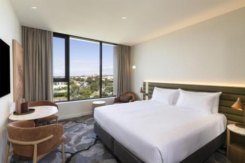 a hotel room with a bed and a large window at Adina Chermside Brisbane in Brisbane