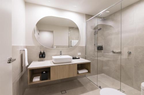 a bathroom with a sink and a shower at Adina Chermside Brisbane in Brisbane