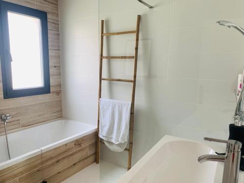 a bathroom with a white bath tub and a sink at Casa da Fonteseca a pie de playa in Ribeira