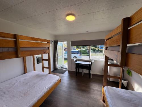 a bedroom with two bunk beds and a desk at Cambridge Top 10 Holiday Park in Cambridge