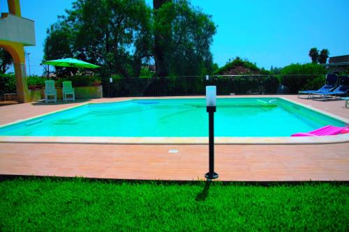 a swimming pool with a candle in the grass at Happy Holiday Villa - Pool & Garden in Syracuse