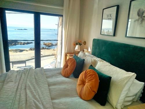 a bedroom with a bed with a view of the ocean at Casa da Fonteseca a pie de playa in Ribeira