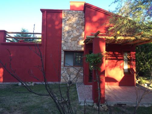 a house with a red facade and a patio at Raco De La Calma in Nono