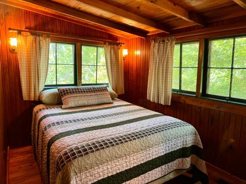 a bedroom with a bed in a room with windows at 4-OH, DEER! - Historic Five Points Lake Hamilton in Hot Springs
