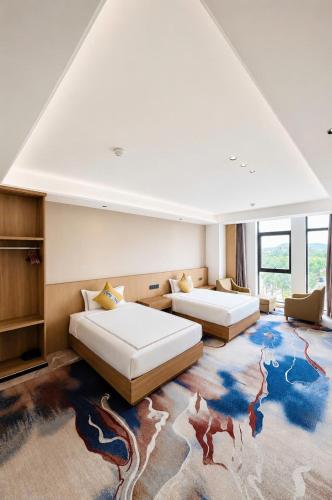 a large room with two beds and a large rug at Kim Thành Hotel in Bắc Ninh