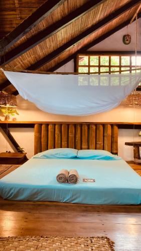 a bedroom with a bed with two hats on it at La Caleta House in Mompiche