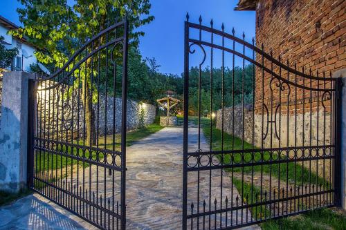 an iron gate to a driveway with a brick building at Garmen Hills Guest Houses in Garmen