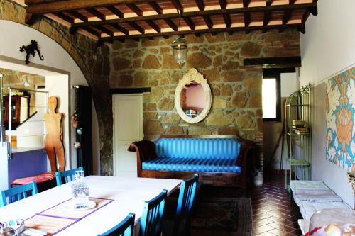sala de estar con mesa y sofá azul en La Casa dei Carrai, en Pitigliano