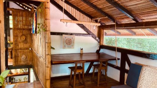 a room with a wooden table in a house at La Caleta House in Mompiche