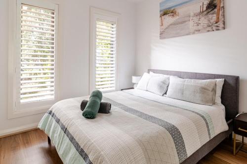 a bedroom with a bed with a green stuffed animal on it at Luxury Capel Sound in Rye