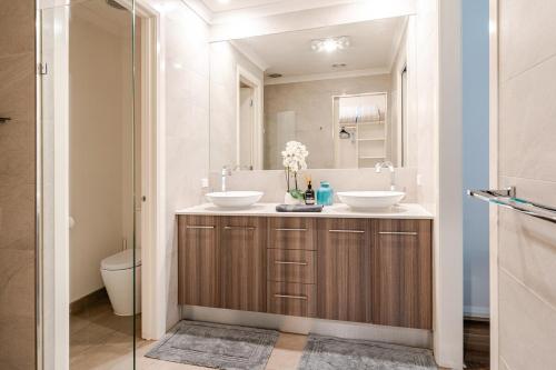 a bathroom with two sinks and a toilet at Luxury Capel Sound in Rye