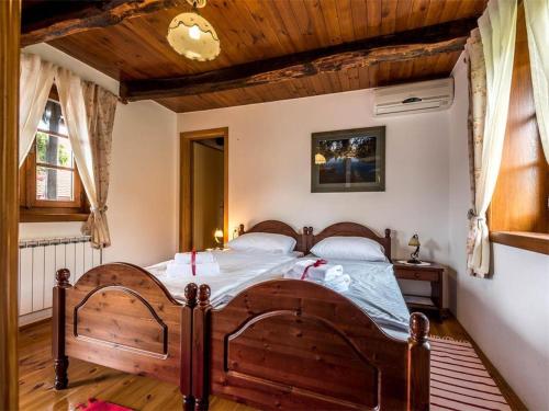 a bedroom with a wooden bed in a room at Nature Escape with Pool & Garden Views in Karlovac
