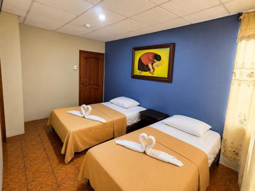 a hotel room with two beds with towels on them at Hotel Milenio in Guayaquil