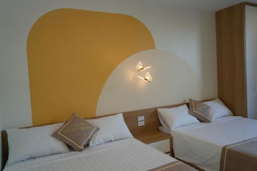a room with two beds and a wall with two lights at Homestay The Pathway Sầm Sơn in Sầm Sơn