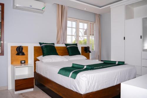 a bedroom with a large white bed with green pillows at Kingston Horizon Retreat in Kingston